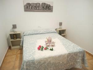 ein Schlafzimmer mit einem Bett mit einem Tisch mit zwei Tassen und Blumen in der Unterkunft Alojamiento rural Barroso Alcobendas in La Puebla de los Infantes