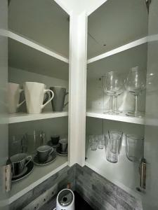 um armário com copos, pratos e copos de vinho em Pacha Residence em Timisoara