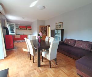 a living room with a dining room table and a couch at Apartman Neva in Sinj