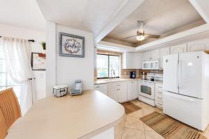 eine Küche mit weißen Schränken und einem weißen Kühlschrank in der Unterkunft Creating Memories by the Canal in Cape Coral