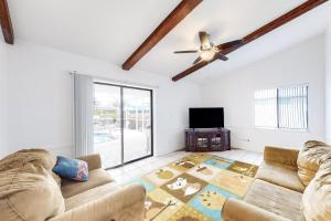 ein Wohnzimmer mit 2 Sofas und einem Deckenventilator in der Unterkunft Creating Memories by the Canal in Cape Coral