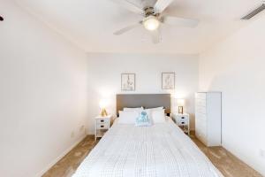 ein weißes Schlafzimmer mit einem Bett und einem Deckenventilator in der Unterkunft Creating Memories by the Canal in Cape Coral + 16 Fotos