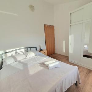 ein Schlafzimmer mit einem großen weißen Bett mit weißer Bettwäsche in der Unterkunft Apartman Neva in Sinj