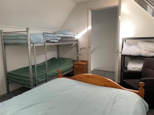 Zimmer mit 2 Etagenbetten und einem Bett in der Unterkunft Heerlijk hoek appartement net buiten het dorp 