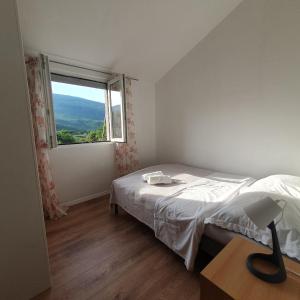 a bedroom with a bed and a large window at Apartman Neva in Sinj