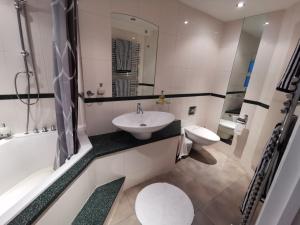 a bathroom with a sink and a tub and a toilet at La de da Frinton on Sea in Frinton-on-Sea +16 photos