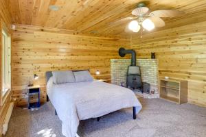 1 dormitorio con 1 cama y chimenea en una cabaña de madera en Cozy Provo Retreat with a Charming Fireplace!, en Provo