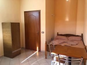 a bedroom with a bed and a table and a door at HOTEL FIRENZE in Tale +19 photos