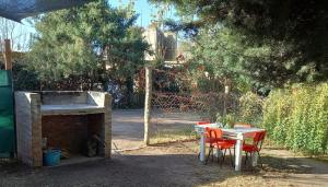 ein Tisch und Stühle und ein Tisch und ein Zaun in der Unterkunft Melen in Maipú + 8 Fotos