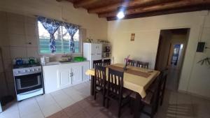 una cocina con mesa y sillas y una cocina con electrodomésticos blancos. en Melen, en Maipú