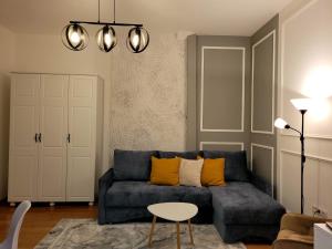 uma sala de estar com um sofá azul e uma mesa em Pacha Residence em Timisoara