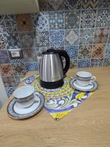 - Hervidor de té y 2 tazas en una mesa en La Rosa Casa Vacanze, en Terzigno