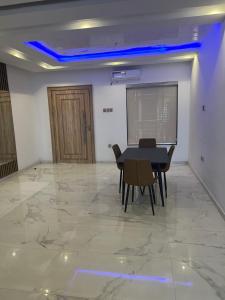 a dining room with a table and chairs on a marble floor at 2 Bedroom Penthouse, Victoria Island Lagos in Maroko