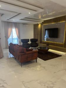 a living room with a couch and a tv at 2 Bedroom Penthouse, Victoria Island Lagos in Maroko