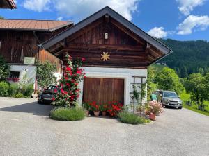 ein Gebäude mit einer Garage mit einem Weihnachtsbaum und Blumen in der Unterkunft Neudegghof in Eben im Pongau