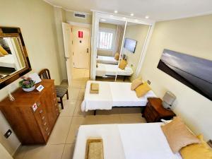 ein kleines Zimmer mit 2 Betten und einem Spiegel in der Unterkunft Apartamento NEPTUNO - Primera Línea de Playa in El Campello