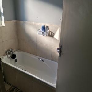 a bath tub in a bathroom with a sink at Pablo and Sons Apartments in Polokwane