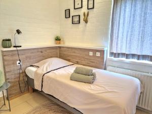 Schlafzimmer mit einem weißen Bett und einem Fenster in der Unterkunft Steef's vakantiehuis zuid limburg in Simpelveld