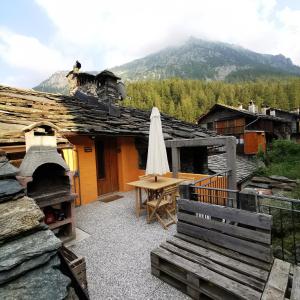 an outdoor patio with a table and an umbrella at casa curnet in Balme