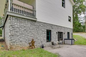 a building with a stone wall next to a house at Killen Vacation Rental Walk to Wilson Lake! in Killen