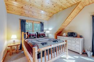 a bedroom with a wooden bed and a wooden ceiling at Pinecone Lodge in Newry