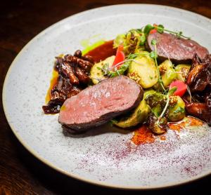 un plato de comida con carne y verduras en una mesa en TERRA penzión, en Jasová