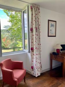 a living room with a chair and a window at La Chatelleraie in Saint-Étienne-de-Maurs