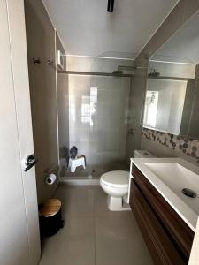 La salle de bains est pourvue de toilettes blanches et d'un lavabo. dans l'établissement Home Cavero, Moderno y completo departamento, à Lima