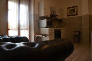 sala de estar con sofá y cocina en RESIDENZA LE TERRAZZE SASSARI CASA G PISCHEDDA bY FANTASTIC SARDINIA, en Sassari