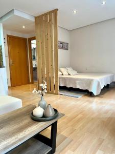 Sala de estar con 2 camas y mesa en Suite Loft Laurel, en Logroño