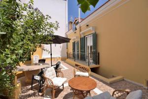 eine Terrasse mit einem Tisch, Stühlen und einem Sonnenschirm in der Unterkunft Casa Di Rodi in Rhodos (Stadt)