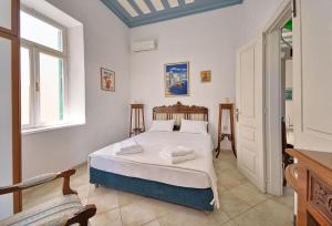 a bedroom with a bed with white sheets at Casa Di Rodi in Rhodes Town