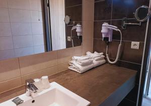 a bathroom with a sink and a mirror and towels at Le Cheval Blanc in Arles