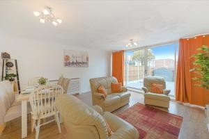 ein Wohnzimmer mit einem Sofa, Stühlen und einem Tisch in der Unterkunft 10% discount on long stays in Chigwell