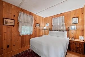1 dormitorio con cama blanca y paredes de madera en Dreamy Paradise Point, en Brant Lake