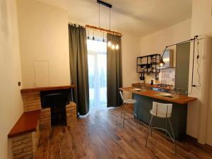 a room with a kitchen with a counter and a table at Appartamento Olivo in Collecorvino