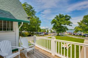a porch with two chairs and a view of a street at Portage Lake Condo with Deck and Pool Access! in Onekama