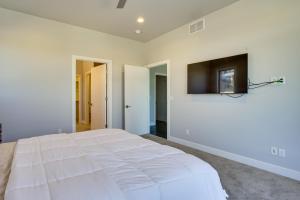 1 dormitorio con 1 cama blanca y TV de pantalla plana en Hideout Haven Luxe Retreat with Lake View and Hot Tub, en Keetley