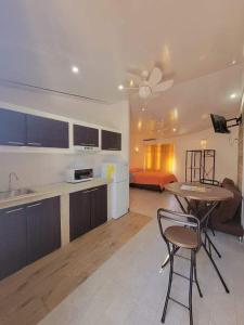 INGRID LOFTS في لا يونون: مطبخ وغرفة معيشة مع طاولة وكراسي