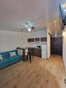 uma sala de estar com um sofá azul e uma cozinha em INGRID LOFTS em La Unión