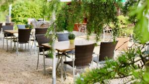 eine Gruppe von Tischen und Stühlen in einem Garten in der Unterkunft Kulinarium an der Glems in Stuttgart