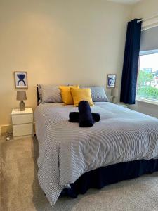 a bedroom with a large bed with yellow and blue pillows at Tithebarn Townhouse in Poulton le Fylde