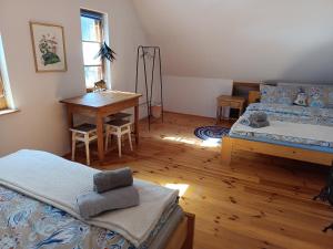 a bedroom with two beds and a table and a desk at Dębowe Królestwo Leśniczówka w Puszczy na wyłączność in Policzna