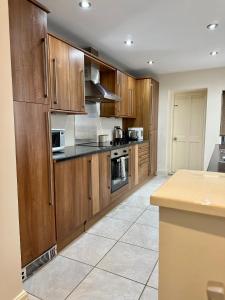 a large kitchen with wooden cabinets and appliances at Tithebarn Townhouse in Poulton le Fylde