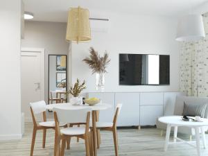 a dining room with a white table and chairs at Stacja Baltic Twins in Sztutowo