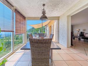 a dining room with a table and chairs and windows at Spa Mas Baucour in Grasse