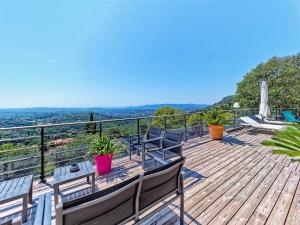 una terraza de madera con sillas y una mesa. en Spa Mas Baucour, en Grasse