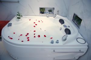 a white bath tub with red hearts on the floor at Sharz Hotel in Buraydah