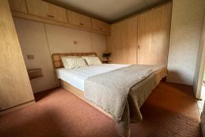 a bedroom with a large bed with wooden cabinets at Domek holenderski in Rydzewo