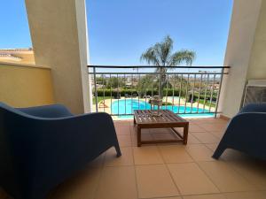 balcón con mesa y piscina en Paraíso da Ria Formosa, en Faro